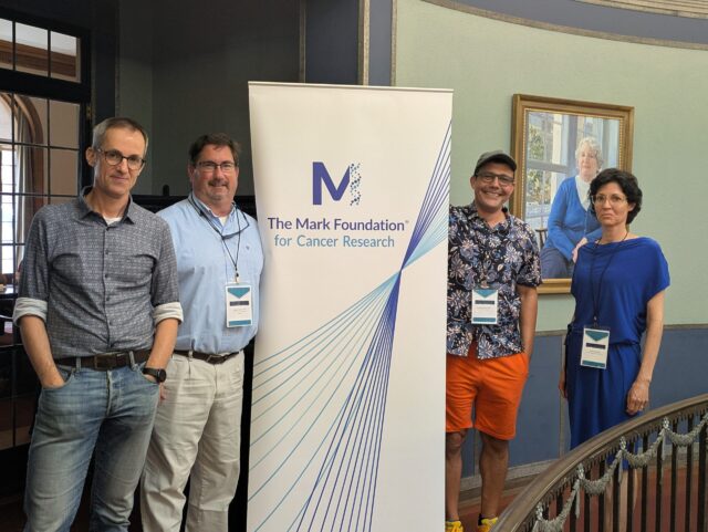 Event organizers at the Mark Foundation for Cancer Research's workshop on chromosomal instability in cancer pose in front of a standing banner with the Mark Foundation logo.
